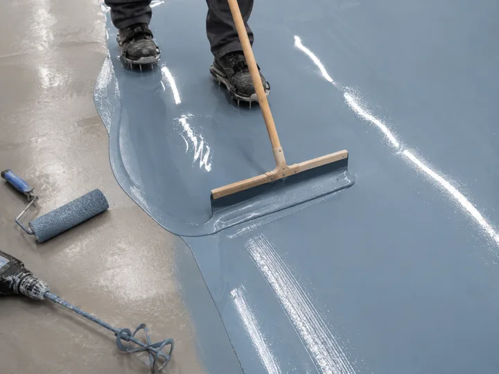 Wet flood coat being pulled with a squeegee, mixing drill and roller at the edge of frame